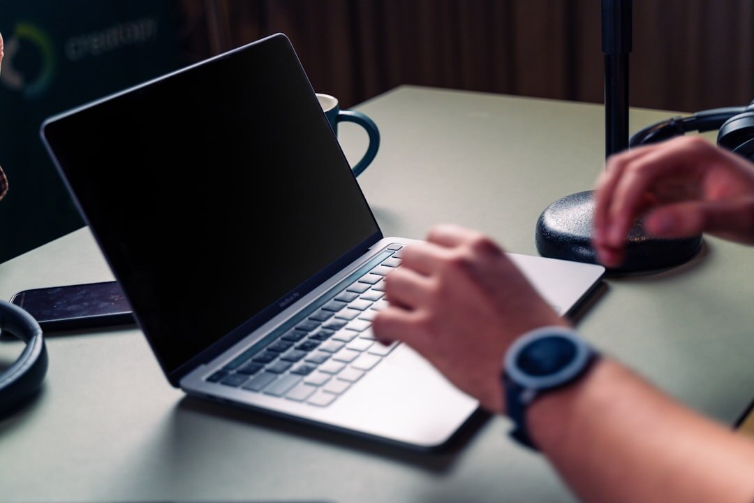Journalist writing a news story on a laptop in a newsroom